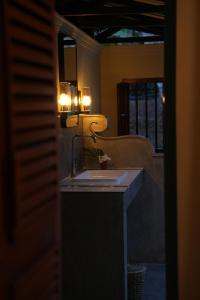 a bathroom with a sink and a mirror at La'Litha Villa in Bentota