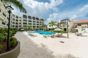 a resort with a pool and chairs and a hotel at PC209 - Pool View - Perfect for families or group - Close to Palm Beach - 2BR in Palm-Eagle Beach