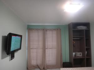 a bedroom with a flat screen tv on the wall at Ajuricaba Suites 1 in Manaus