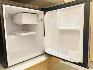 an empty refrigerator with its door open in a kitchen at Micasa at Green 2 Residences in Dasmariñas