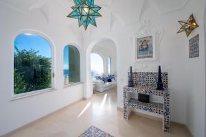 a white room with a chair and windows at Estate4home - Regina Dar adults only in Positano
