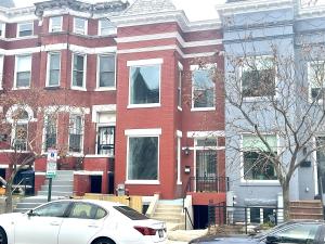 a white car parked in front of a red brick building at North Capitol Charm in Washington, D.C.