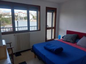 ein Schlafzimmer mit einem blauen Bett und einem Fenster in der Unterkunft Chambre B1 dans un appartement en colocation in Marseille