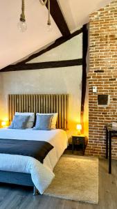 una camera da letto con un letto e un muro di mattoni di Appartements de caractère - Cœur de ville a Pont-Audemer