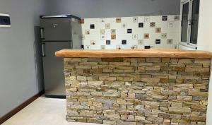 a kitchen with a stone counter and a refrigerator at Casa Apacheta in San Antonio de Areco