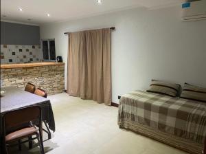 a bedroom with a bed and a table in it at Casa Apacheta in San Antonio de Areco