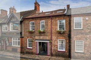 a brick building with white windows on a street at Minster Walk Guesthouse in York