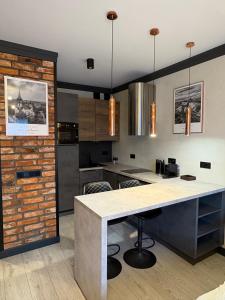 a kitchen with a table and a brick wall at Riverside Industrial Studios - SAUNA-GYM- Stay in style by WroApart-PL -air-conditioning-all-SPA-FITNESS in Wrocław