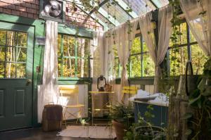 a greenhouse with curtains and plants in it at Trekker, Treehouses cabins and lodge rooms in Lake George