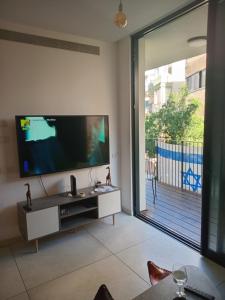 a living room with a large flat screen tv at luxurious apartment by Dizengoff square in Tel Aviv +1 photo