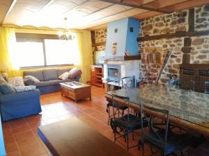 ein Wohnzimmer mit einem Tisch und einem Steinkamin in der Unterkunft Casa rural San Felices in San Felices de Castillería