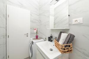 a white bathroom with a sink and a toilet at Apartmants Šestić in Tučepi +44 photos