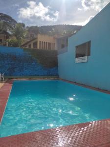 a large blue swimming pool next to a building at Chalé Serrano in Guaramiranga