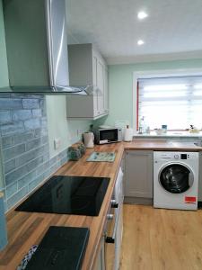 eine Küche mit Waschmaschine und Trockner auf der Theke in der Unterkunft Hytheview Cottage Whitehills in Whitehills