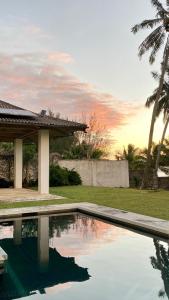 a swimming pool in front of a house at Manna Villa - Sovereign Palms CI in Arorangi