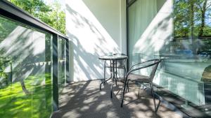 eine Terrasse mit Tisch und Stühlen auf einem Balkon in der Unterkunft Solny Resort Apartament in Kołobrzeg