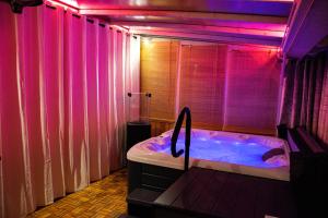 a bathroom with a large tub with pink lights at Domki Na Dobrym Kursie in Jastrzębia Góra