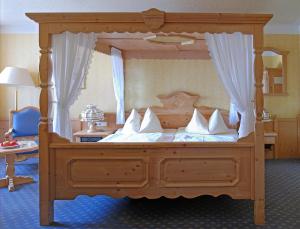 um quarto com uma cama de dossel e almofadas brancas em GROSCH Brauhotel & Gasthof em Rödental
