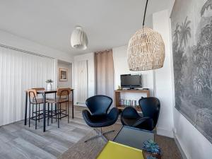 a living room with black chairs and a table at Chic & lumineux avec balcon in Calais
