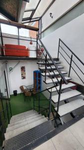una escalera en un edificio con una habitación con una maleta roja en LOFT Centro Historico, en Cusco