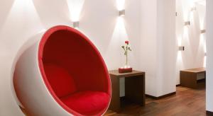 une chaise rouge dans une chambre avec un vase dans l'établissement Hotel Gabbani, à Lugano