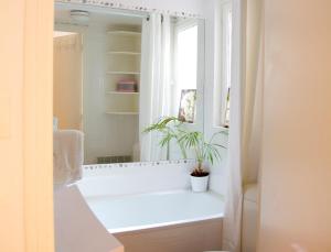パリにあるLe Studio Floreのバスルーム(バスタブ、鏡に植物付)