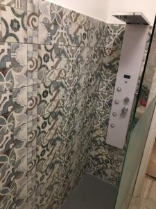 a shower curtain in a bathroom with a patterned wall at My Dream Home in Nettuno