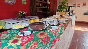 a table with a cake and plates of food on it at Pousada Cipó Prata in Serra do Cipo