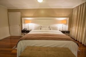 Rúm í herbergi á Hotel Villa Morra Suites