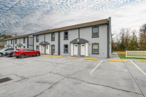 un bâtiment avec une voiture rouge garée sur un parking dans l'établissement Gulfport Condo with Private Balcony - Walk to Beach!, à Gulfport