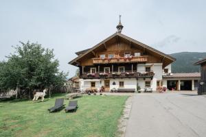 duży budynek z krzesłami przed nim w obiekcie Appartement Arnoldgut w mieście Altenmarkt im Pongau