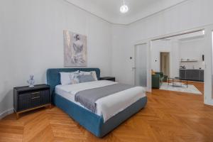 a bedroom with a blue bed and a living room at SUPREME Experience Markovitsz-Palat Istoric-Elegant & Spațios in Oradea