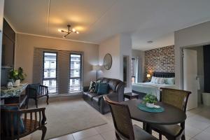 un salon avec un canapé, une table et un lit dans l'établissement Luxury Lowveld Apartment, à Nelspruit