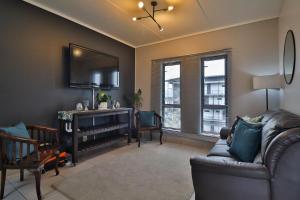 un salon avec un canapé et une télévision dans l'établissement Luxury Lowveld Apartment, à Nelspruit