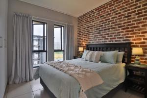 une chambre avec un mur de briques et un lit dans l'établissement Luxury Lowveld Apartment, à Nelspruit