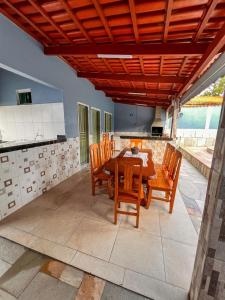 a kitchen and dining room with a wooden table and chairs at kasada Nanda in Pirenópolis