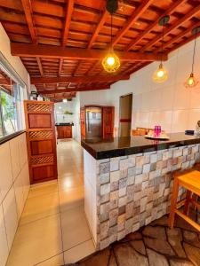 a kitchen with a island in a room with tiles at kasada Nanda in Pirenópolis
