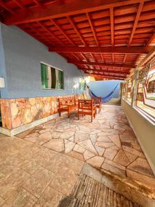 a patio with a table and chairs on a stone floor at kasada Nanda in Pirenópolis