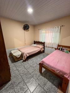 a room with two beds and a window in it at kasada Nanda in Pirenópolis