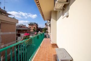 a balcony of a building with a green fence at Roots of Rome Apartment in Rome