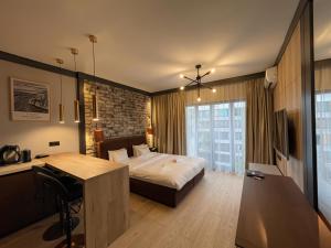 a bedroom with a bed and a desk and a table at Riverside Industrial Studios - SAUNA-GYM- Stay in style by WroApart-PL -air-conditioning-all-SPA-FITNESS in Wrocław