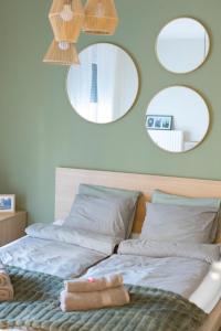 ペーチにあるhellohome apartmanの壁掛け鏡付きベッド