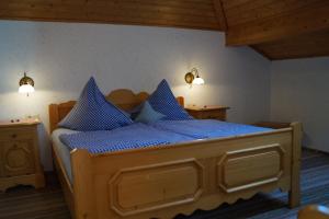 Gästehaus Wagner في Egglfing: غرفة نوم بسرير خشبي مع شراشف زرقاء