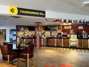 a restaurant with a table and chairs and a bar at Trecco Bay Cwtch Caravan in Newton