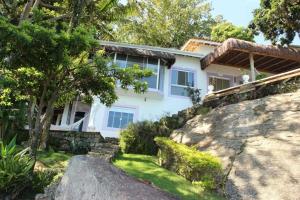 una casa sul fianco di una collina di Studio à Beira Mar em Ilhabela com Vista Deslumbrante IB0001 a Ilhabela