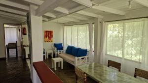 a living room with blue chairs and a couch at Boma Banda Diani - Kusi Cottage in Diani Beach