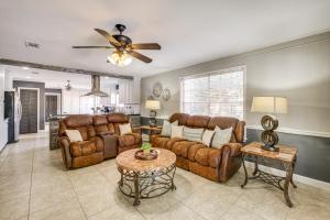 a living room with leather furniture and a ceiling fan at 2 Mi to Gulfport Beaches Poolside Paradise! in Gulfport