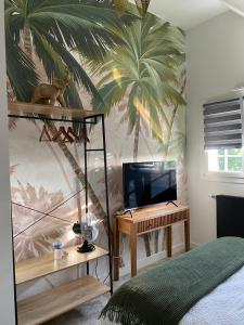 a bedroom with a palm tree mural on the wall at Lady Jule Chambres d hôtes & spa in Sainte-Luce-sur-Loire