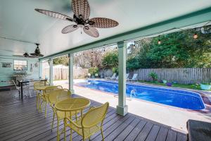 a patio with chairs and a pool and a ceiling fan at 2 Mi to Gulfport Beaches Poolside Paradise! in Gulfport