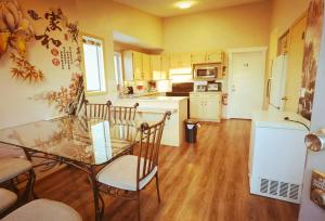 una cocina con mesa de cristal y sillas. en Home Inn Calgary Tuscany, en Calgary
